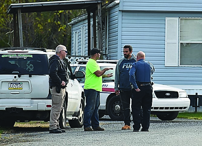 Mirror photo by J.D. Cavrich Local police and Clear Creek Company officials speak outside of a mobile home at Blair Mobile Home Park in East Freedom on Monday.
